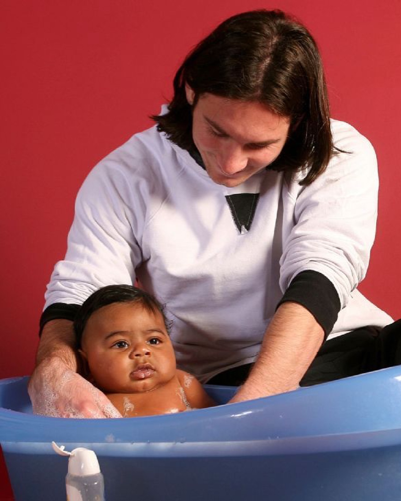 Lionel Messi bathing a baby Lamine Yamal during a 2007 Barcelona charity calendar shoot.