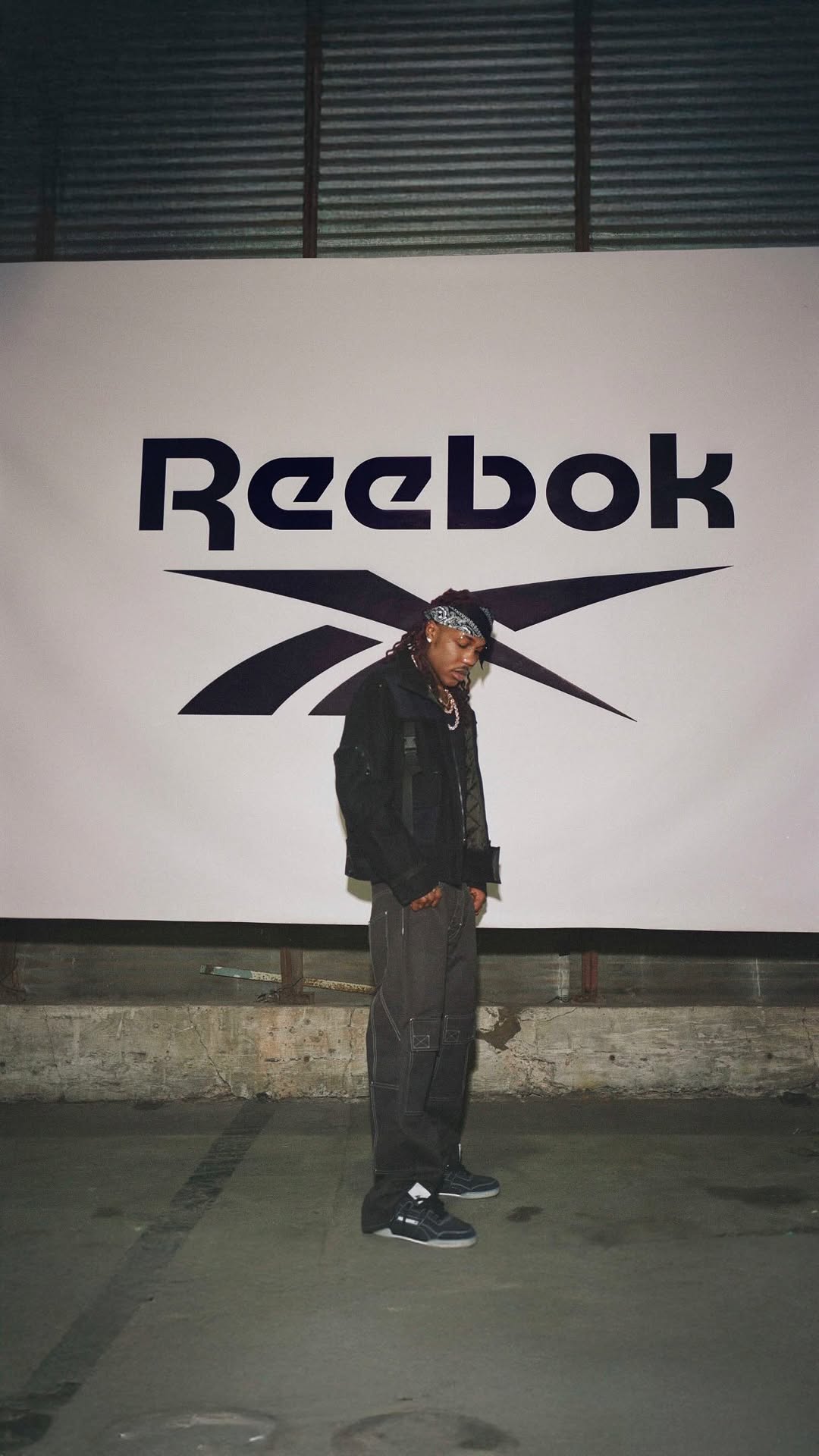 Destroy Lonely crouched in denim, wearing Reebok's white Workout Plus sneaker for the Born Classic campaign.