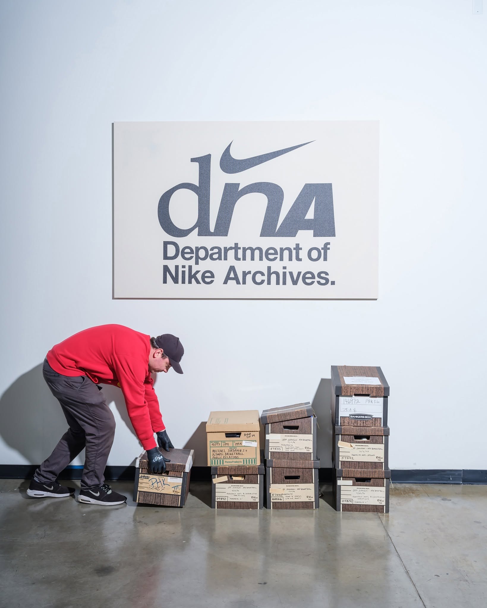 A staff member handles archive boxes beneath the Department of Nike Archives sign in Beaverton.