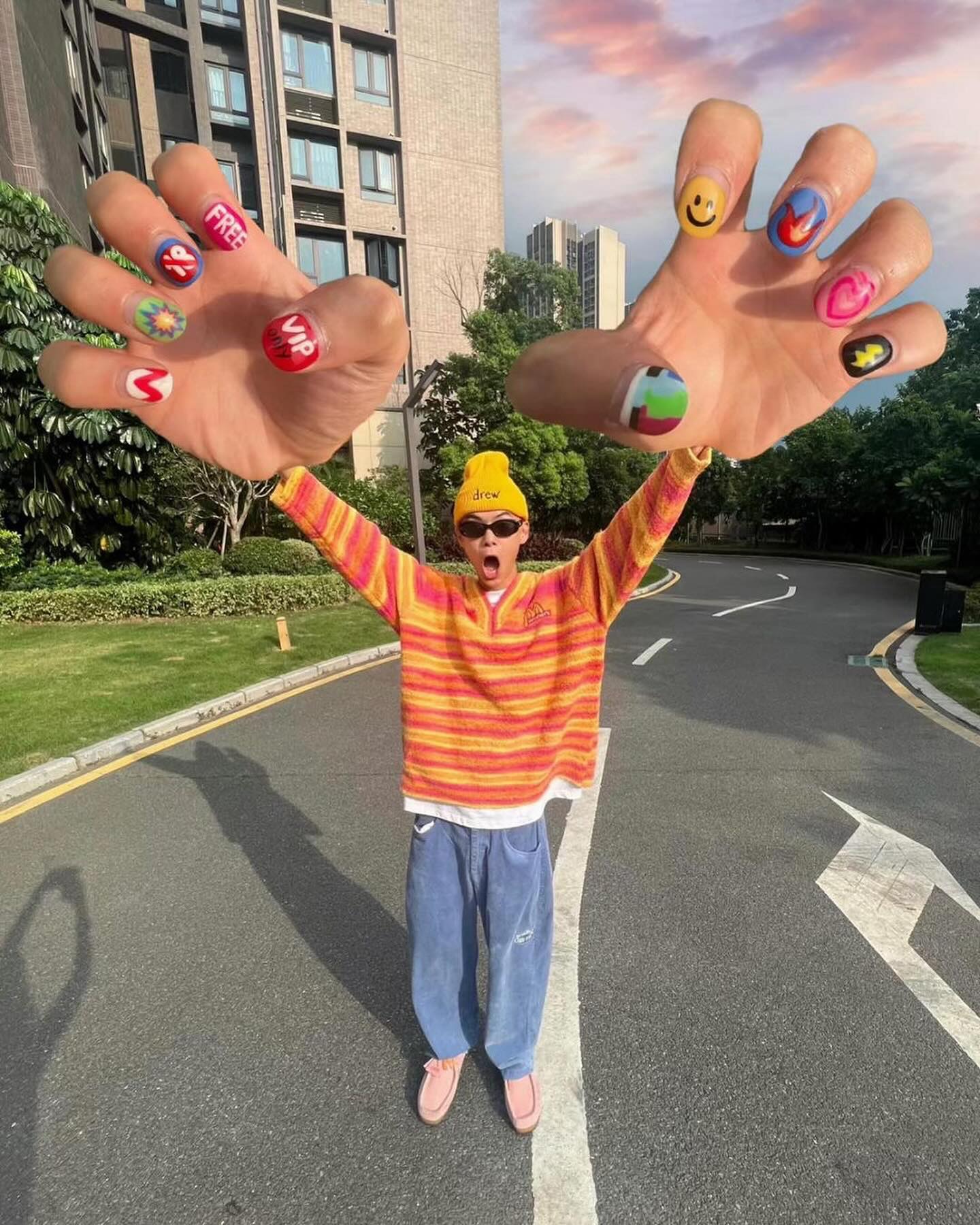 A forced perspective photo from the wide angle big hands trend, showing an outstretched hand and manicure enlarged in the foreground against a shrunken body.