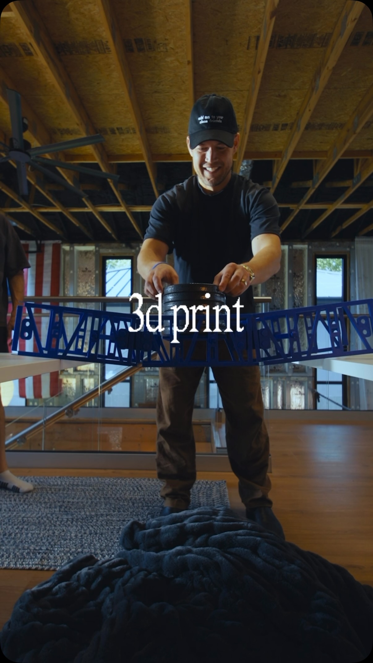 The Agent Wars creator stands behind a blue printed bridge in the workshop.
