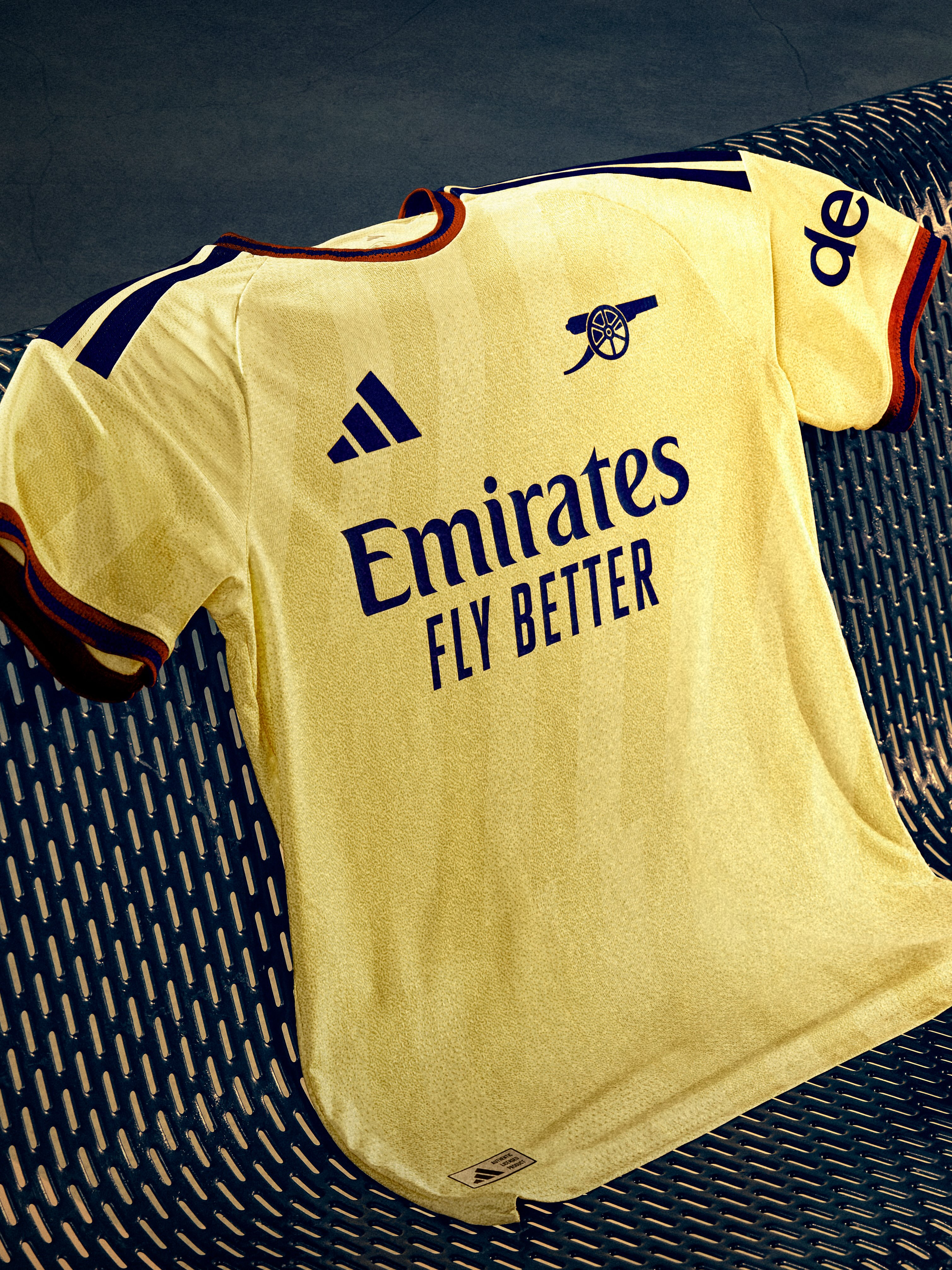 Arsenal's pale yellow 2026/27 third jersey with navy trim and a minimalist cannon crest