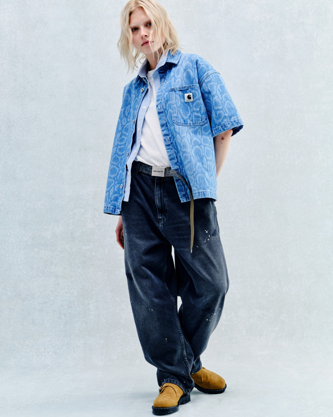 Carhartt WIP SS26 campaign image showing the snake camo print on a womens denim shirt and shorts