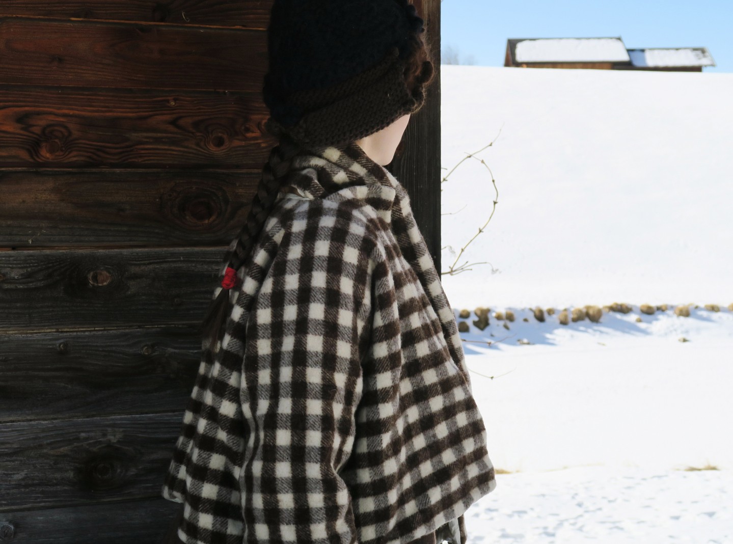 A model wears a roomy checked Daniela Gregis layer in a snowy setting.