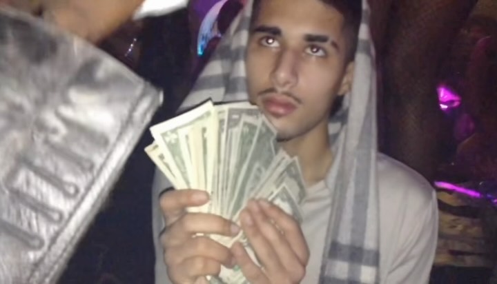 A hooded figure holds a fan of cash in Fakemink’s purple lit release image.