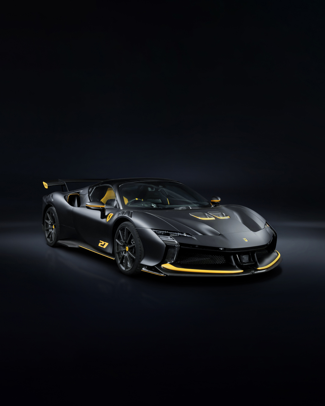 A matte Nero Galaxy Ferrari SF90 XX Spider with Blazing Yellow accents along the front air intakes and side skirts, part of the Ferrari Tailor Made Scuderia Collection.