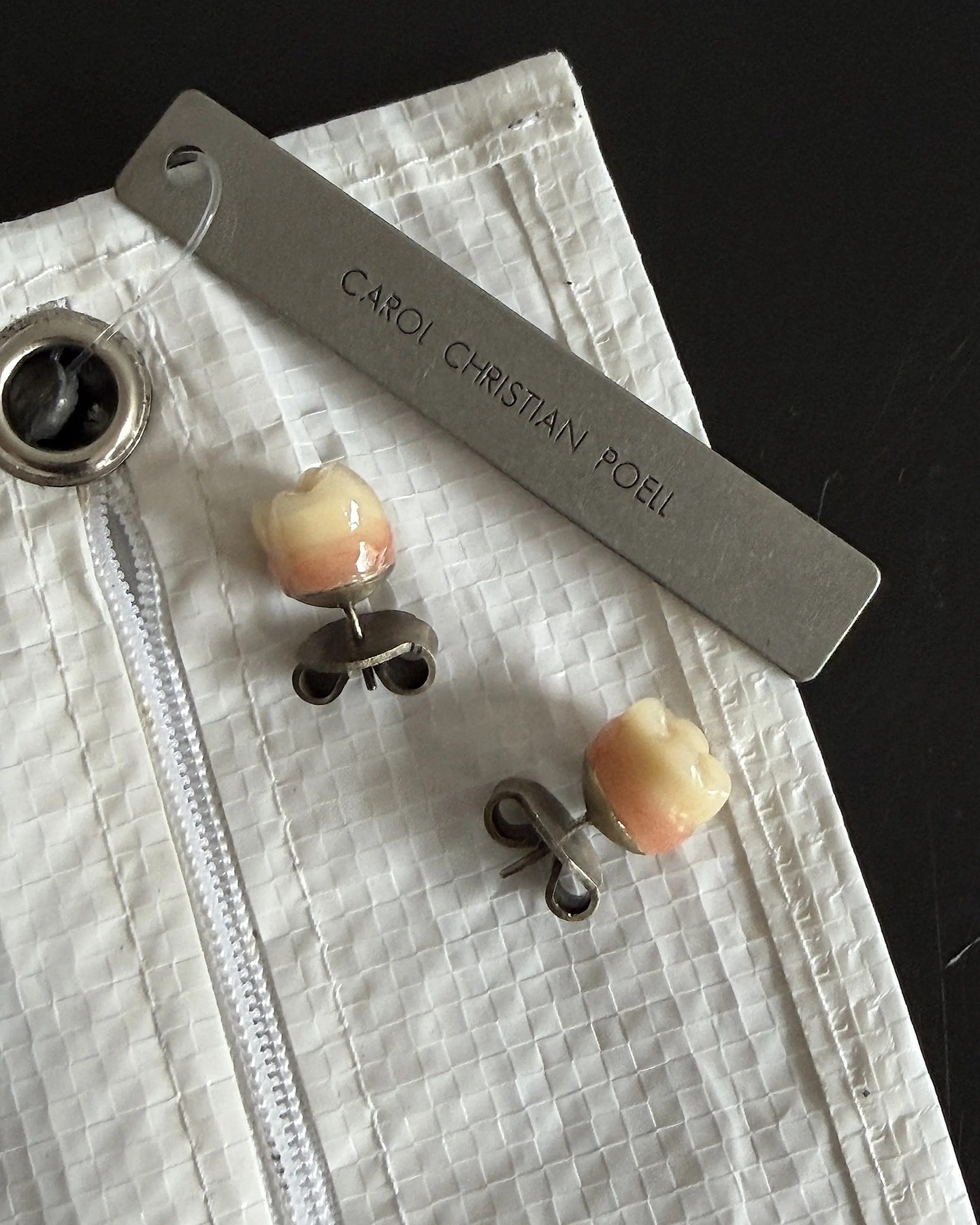 A silver stud earring set with a prosthetic tooth from Carol Christian Poell's jewelry line.