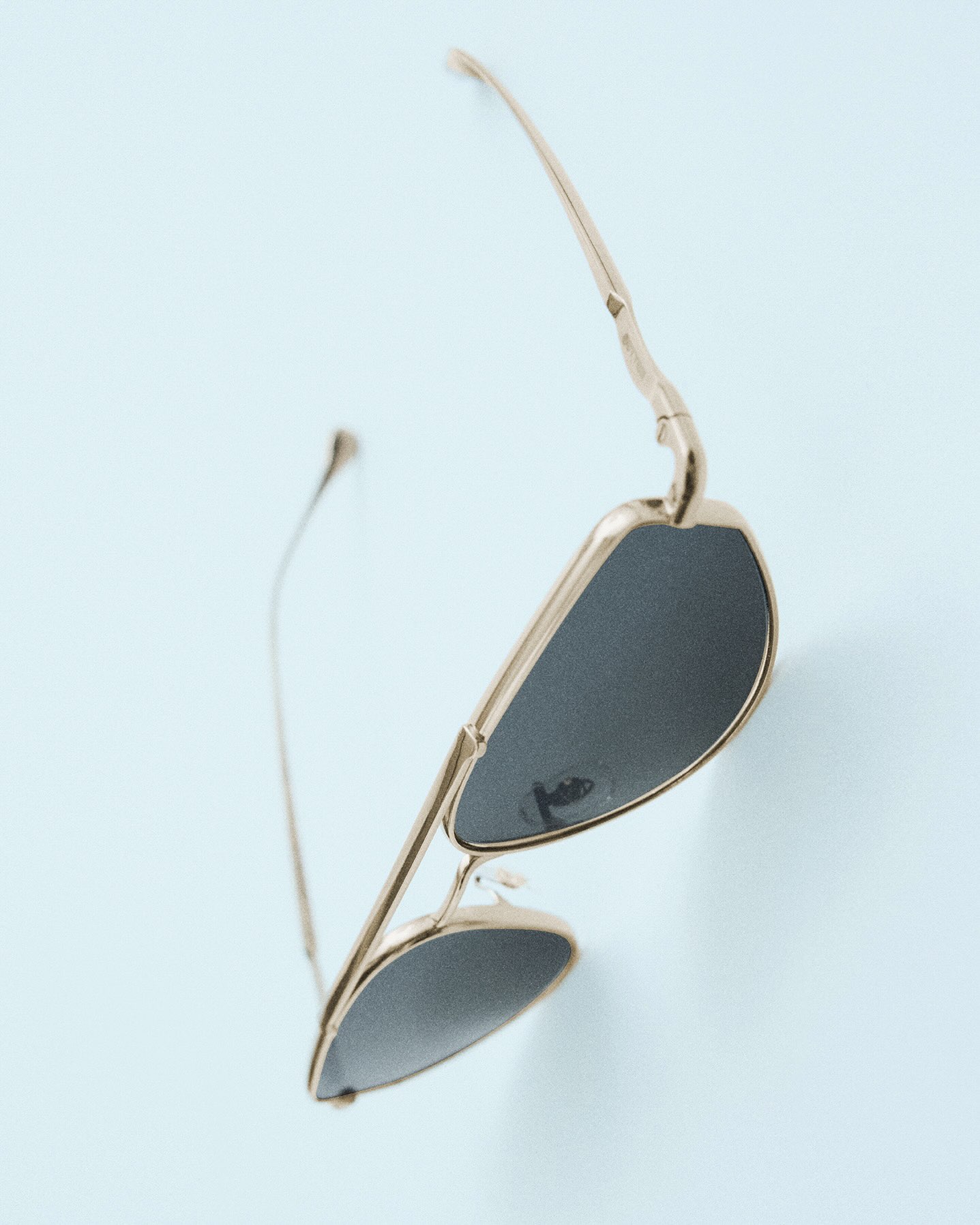 A titanium Jil Sander Oliver Peoples Edition 5 aviator sunglasses frame shown with drop shaped lenses.