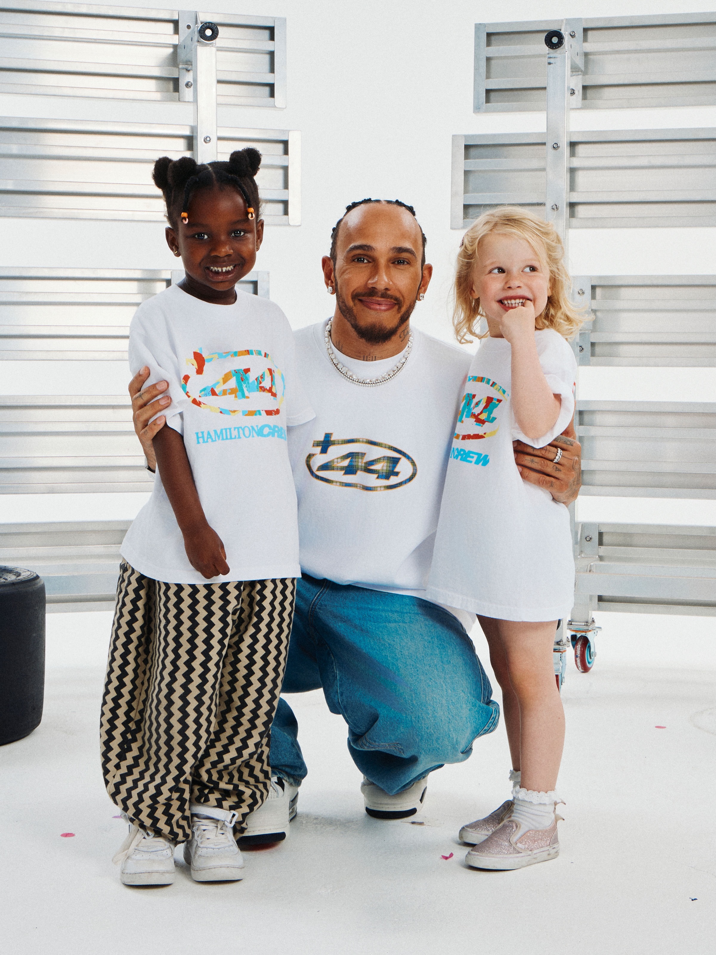 Lewis Hamilton in Ferrari red greets fans wearing Plus44 apparel at Silverstone during British Grand Prix week.