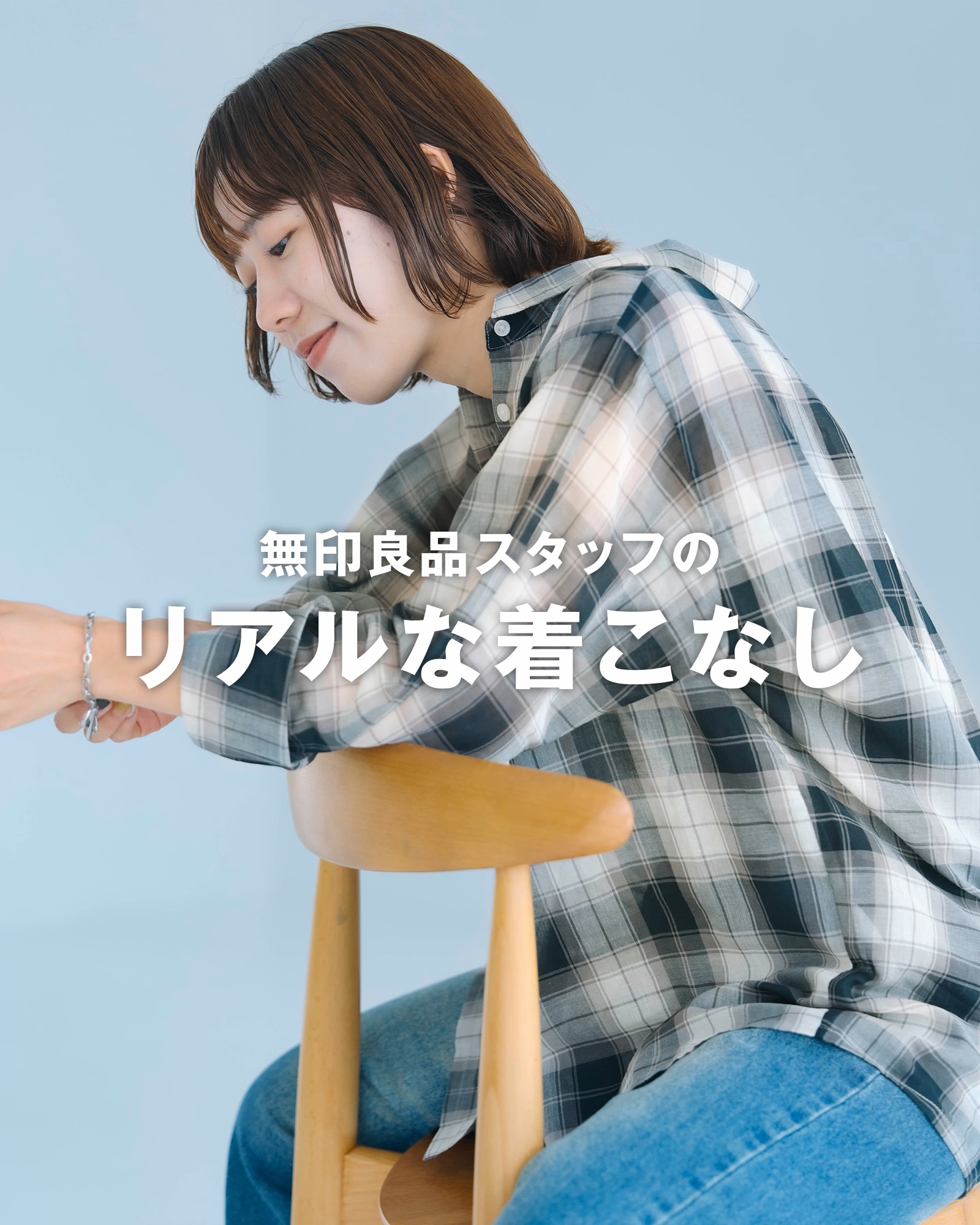 A MUJI staff member styling MUJI clothing in a store setting