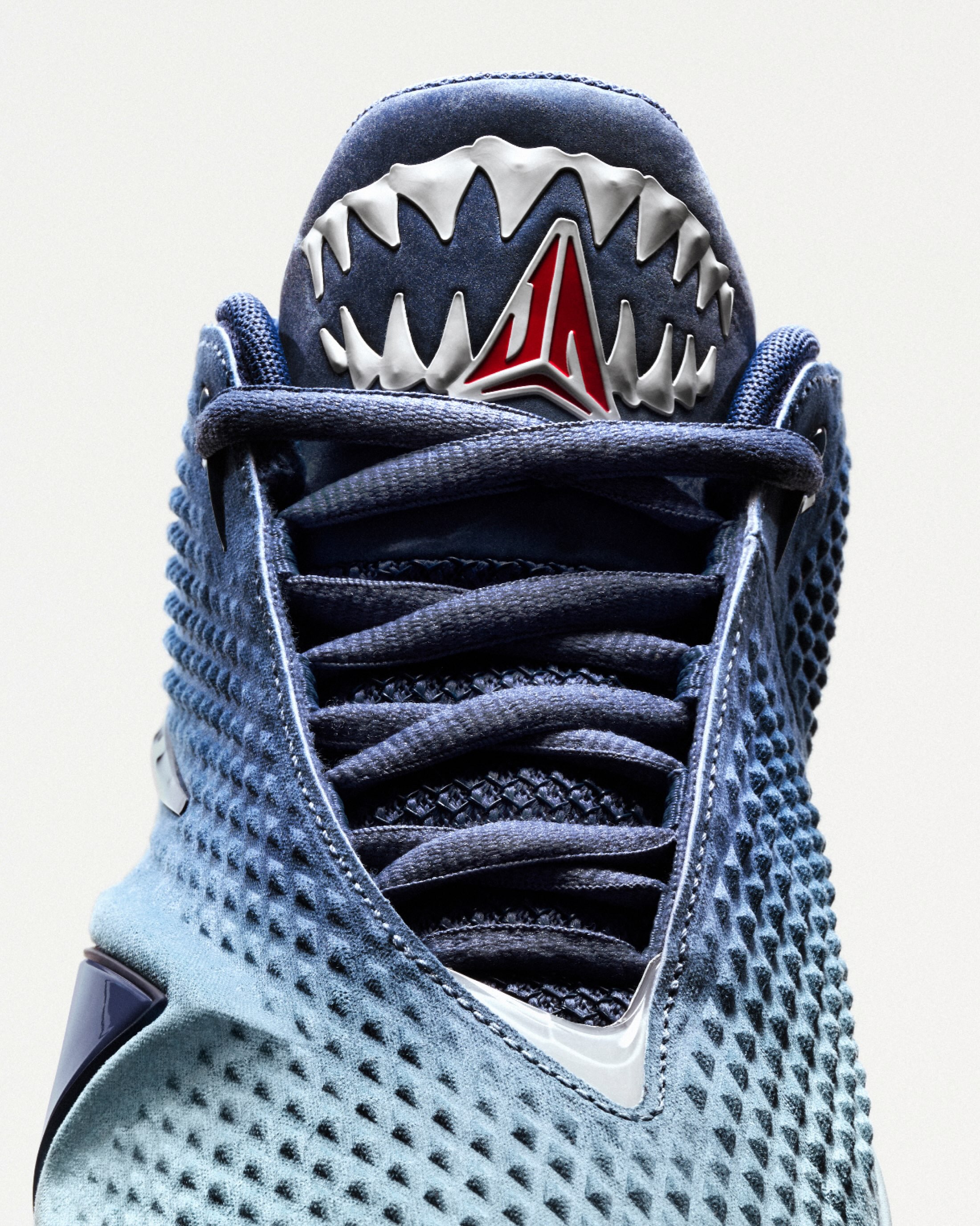 Blue Nike Ja 4 Deep Water shoes show teeth around the tongue graphic.