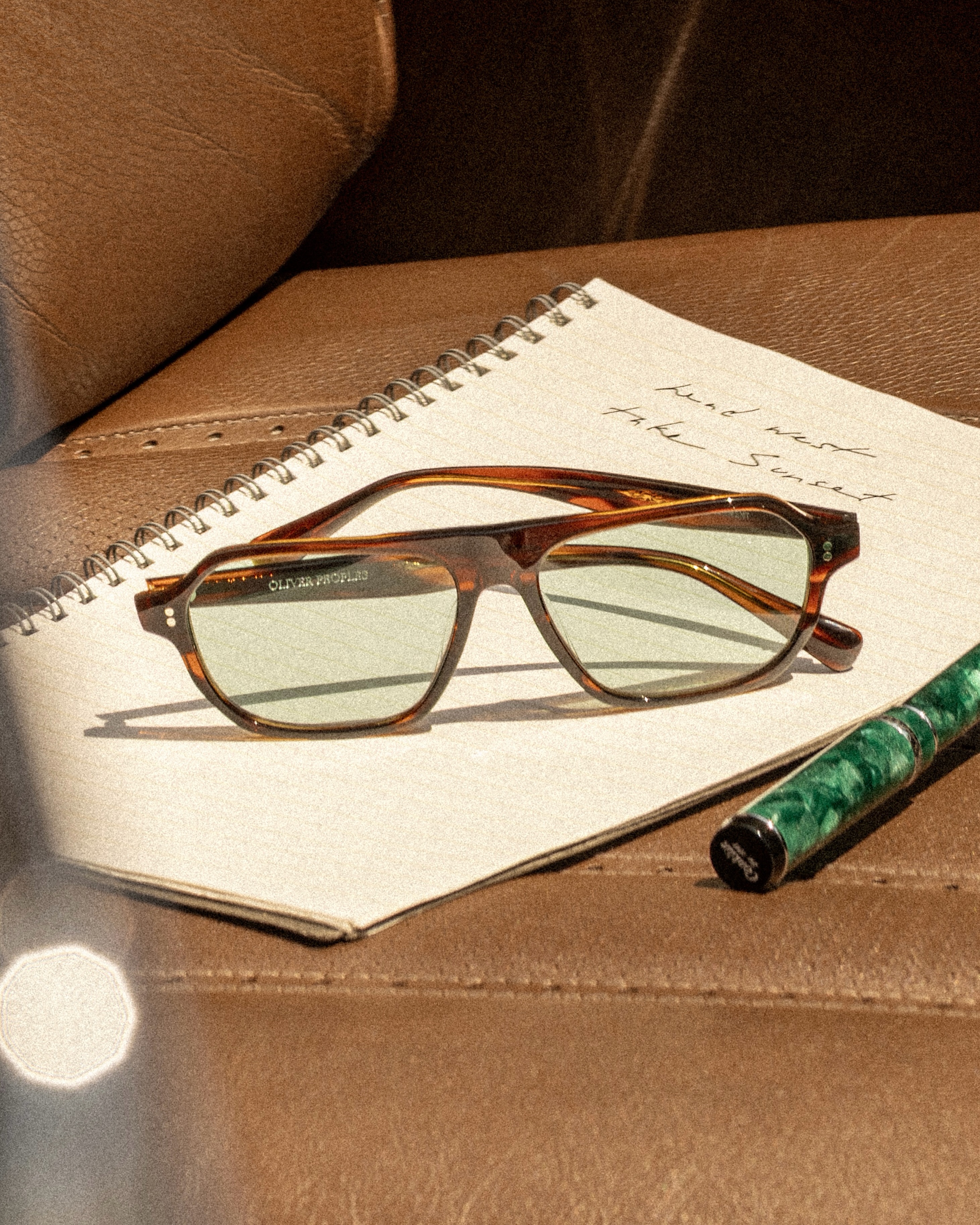 A campaign image for Oliver Peoples' Remment sunglasses in the Morado Tortoise colorway, part of the Head West, Take Sunset campaign.