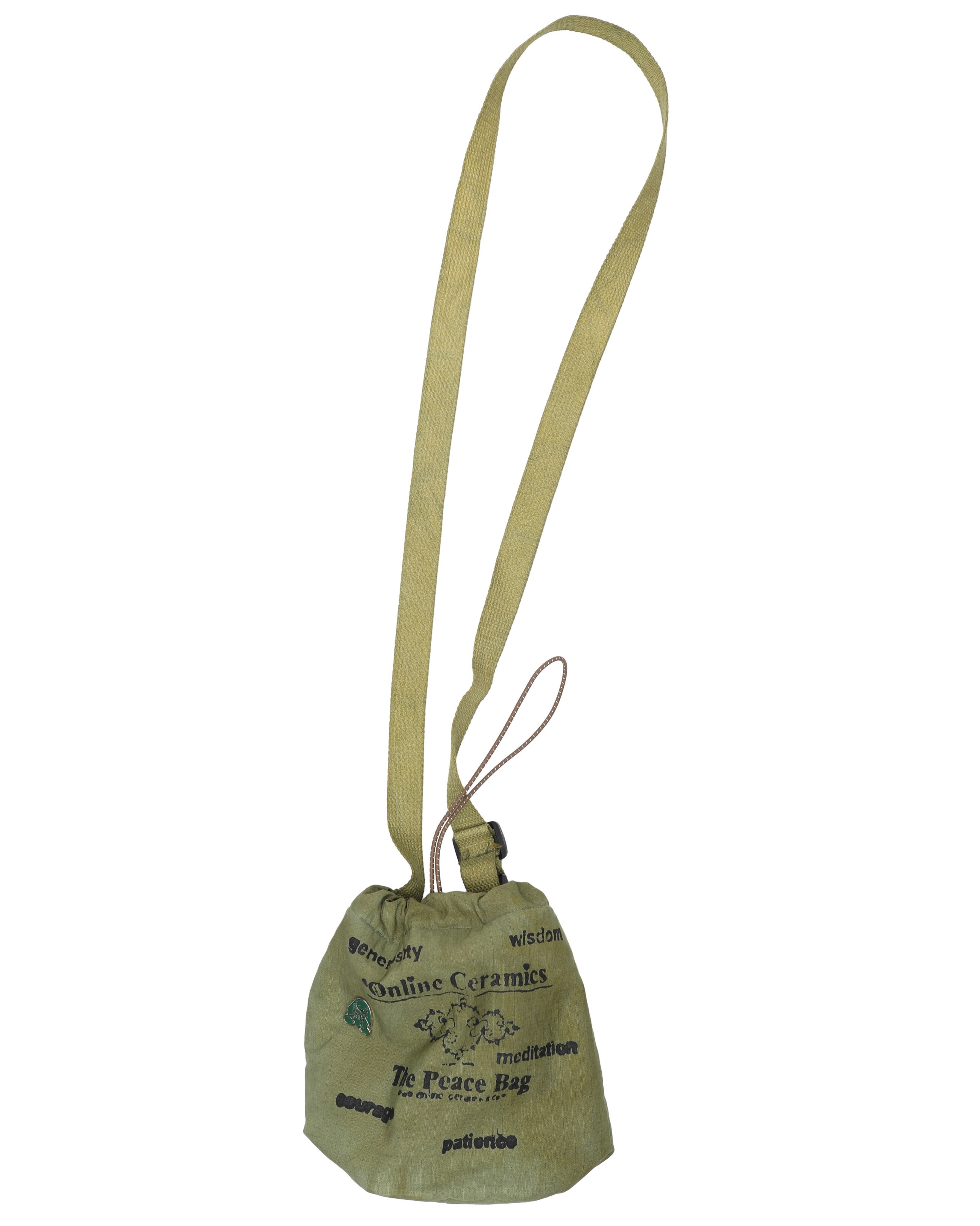 A moss green Online Ceramics Peace Bag carries black lettering and a small bunny pin.