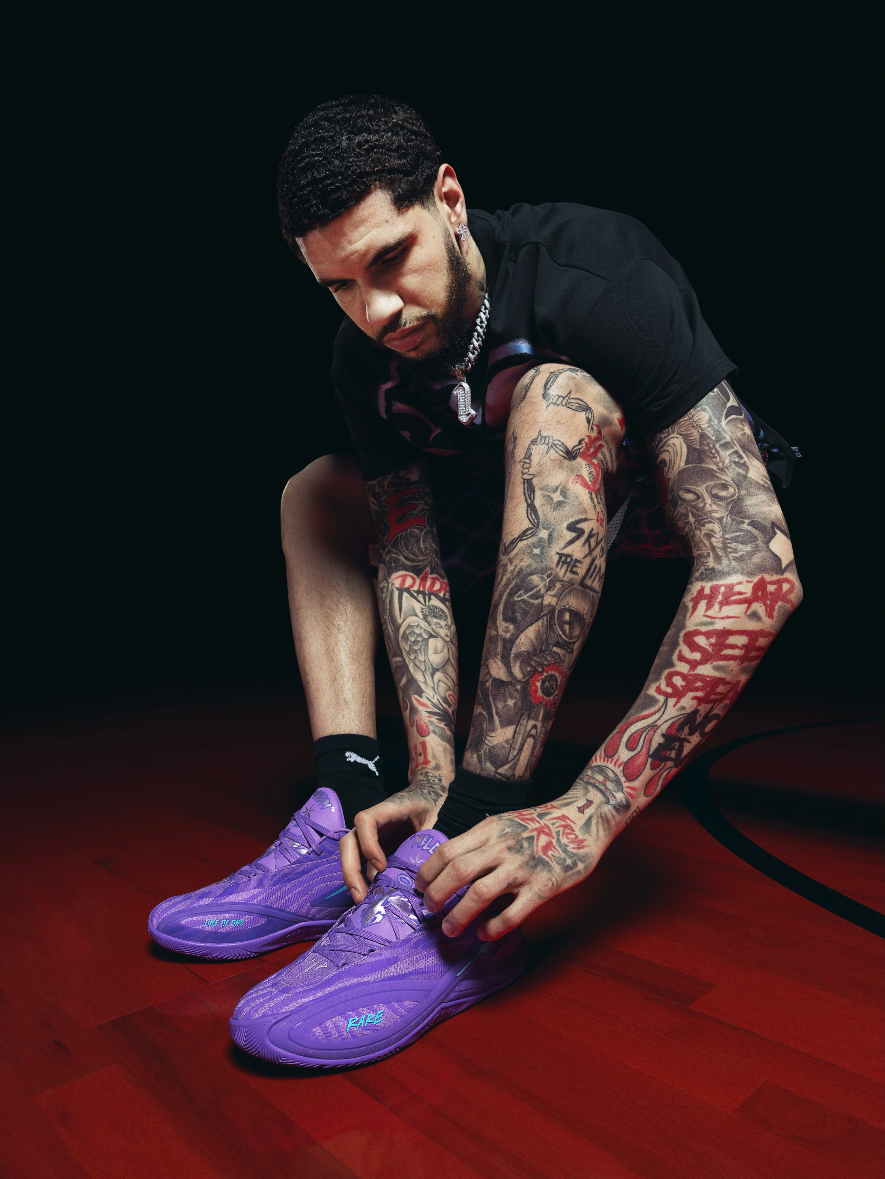 LaMelo Ball wears purple Puma MB.06 Shooting Star shoes on a wooden court.
