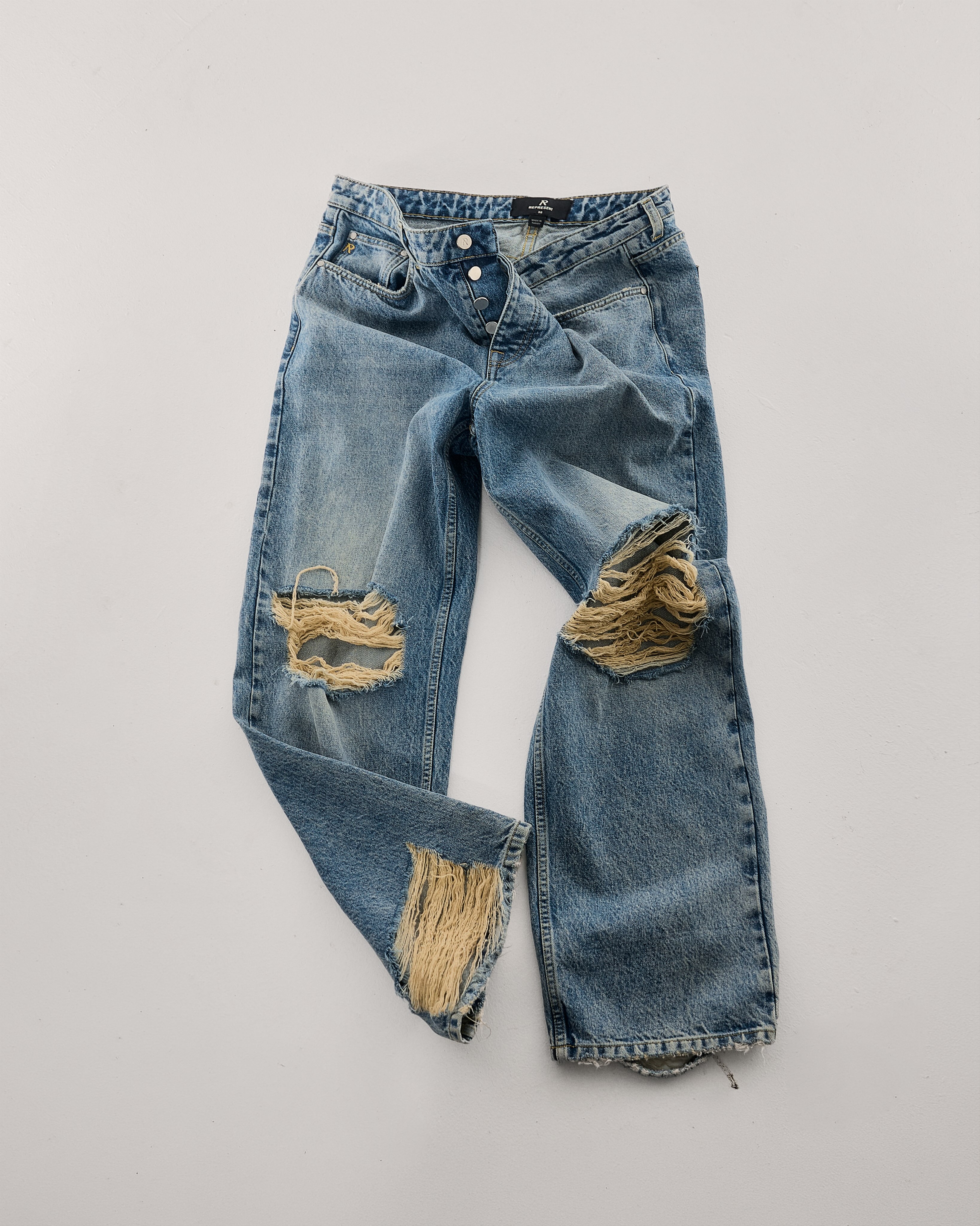 Represent Moss Blue jeans with wide legs and frayed openings at the knees.