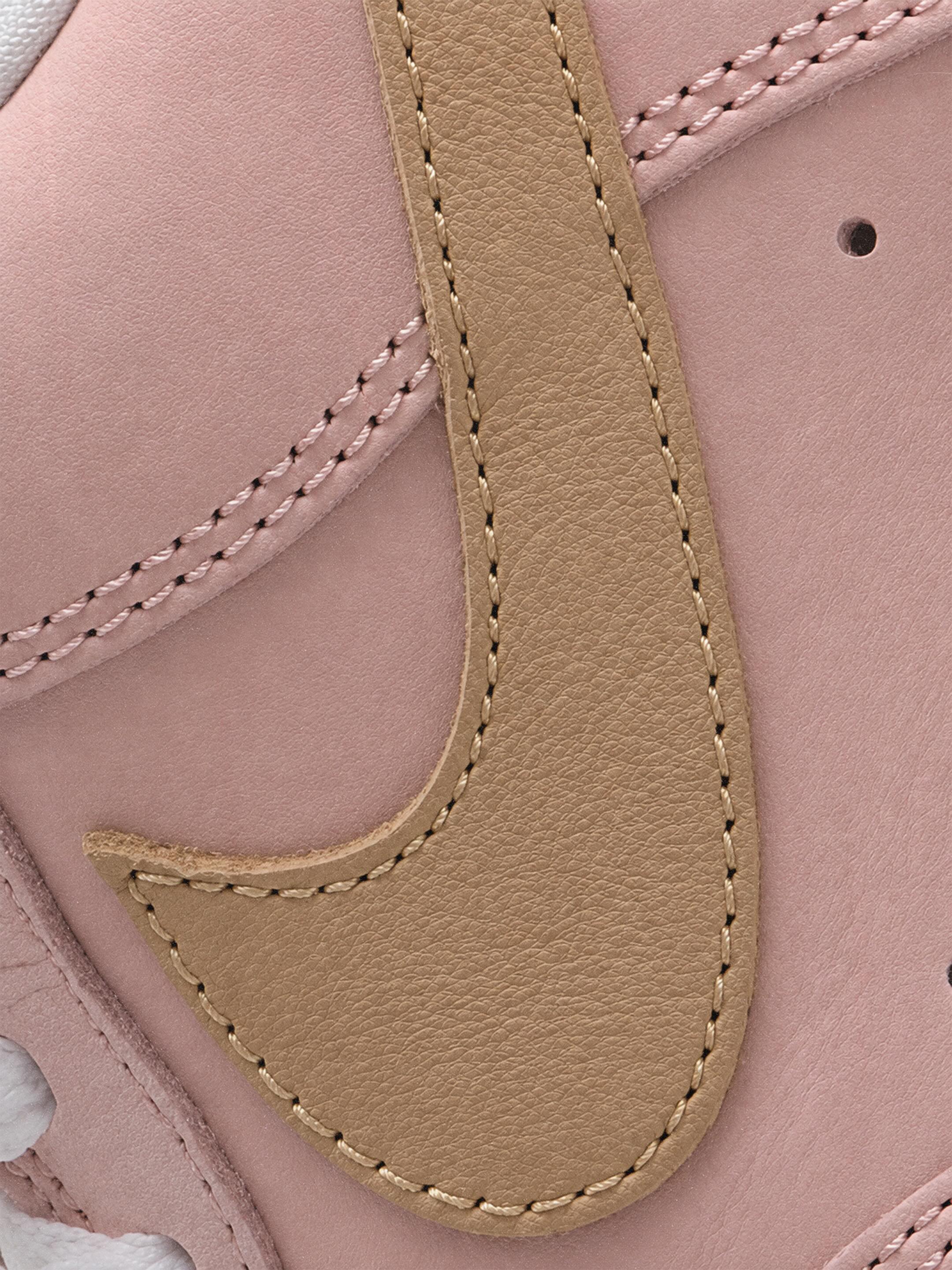 A Nike Air Force 1 Low in the Linen colorway, light brown leather with a pink swoosh and pink outsole.