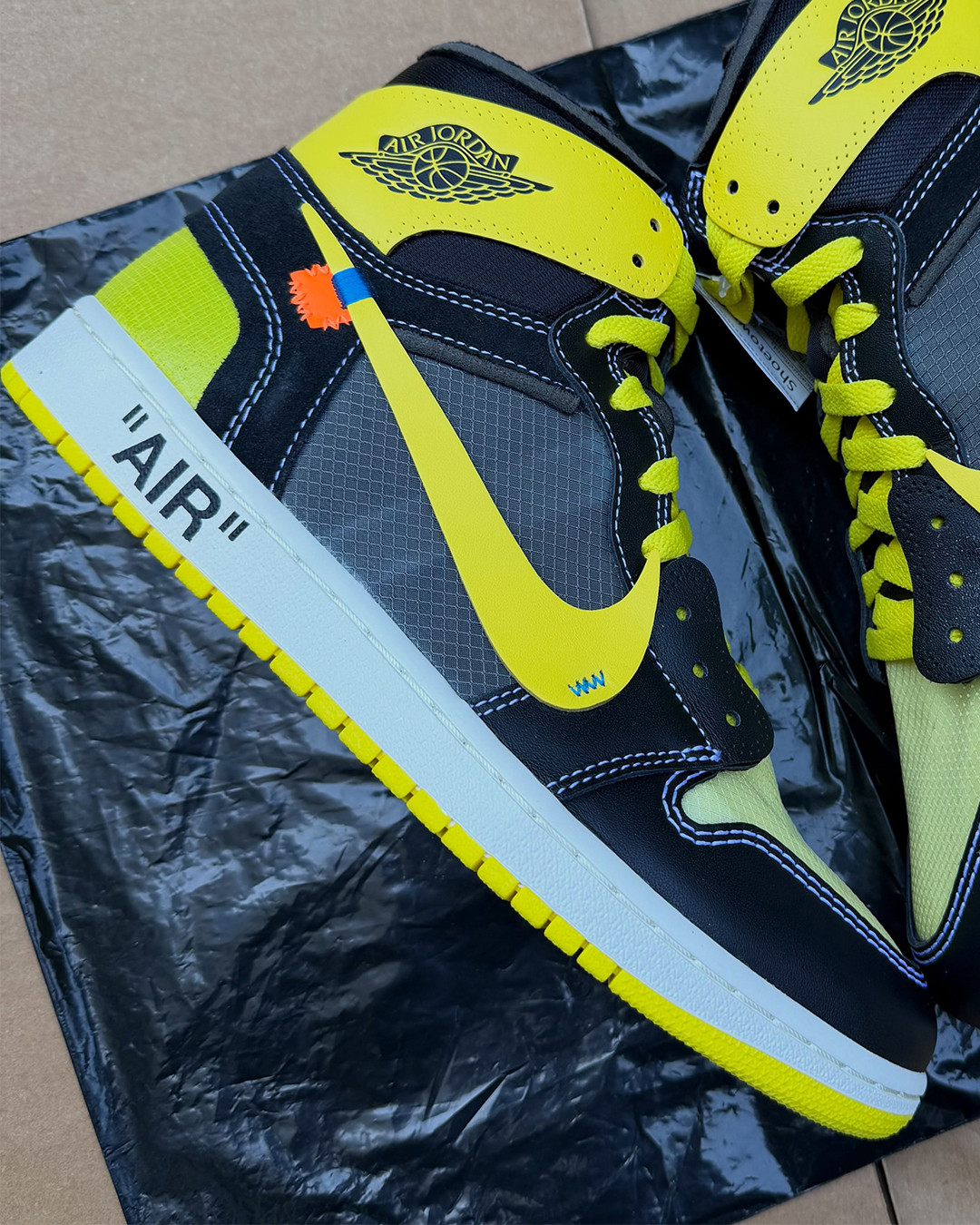 Black and yellow Off White Air Jordan 1 samples show exposed stitching and large Swooshes.