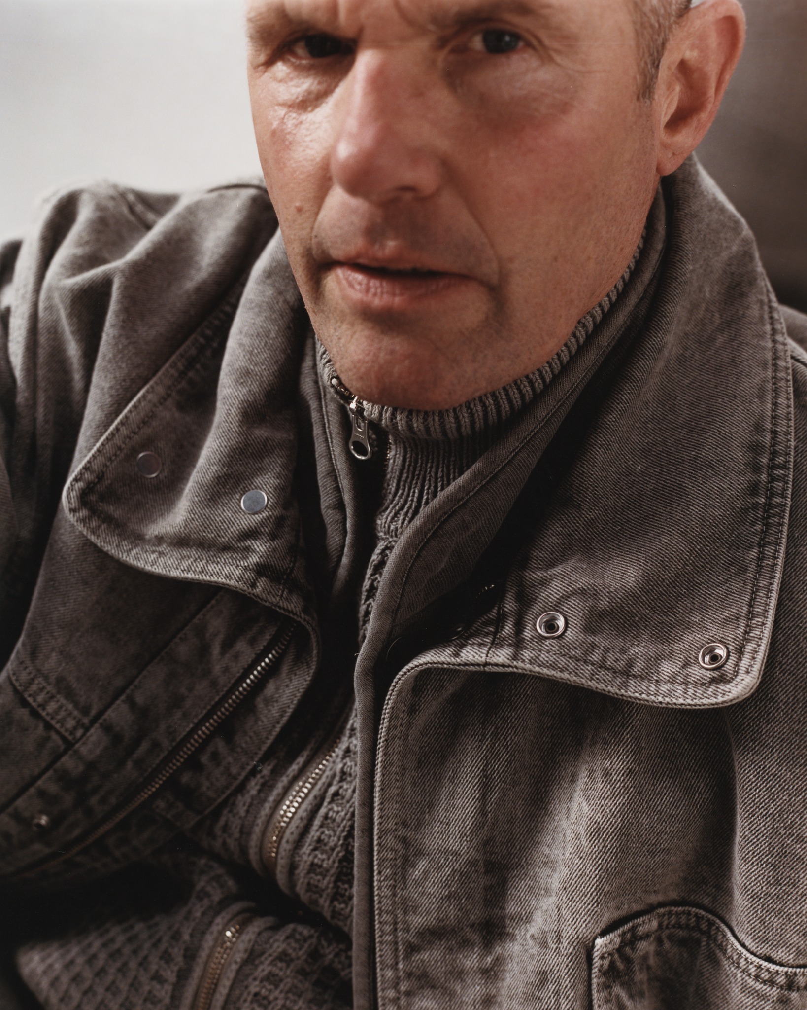 Filmmaker Nick Love photographed in Stone Island's 4100064 mineral dyed cotton gabardine hooded jacket for the AW26 Compass Inside campaign.