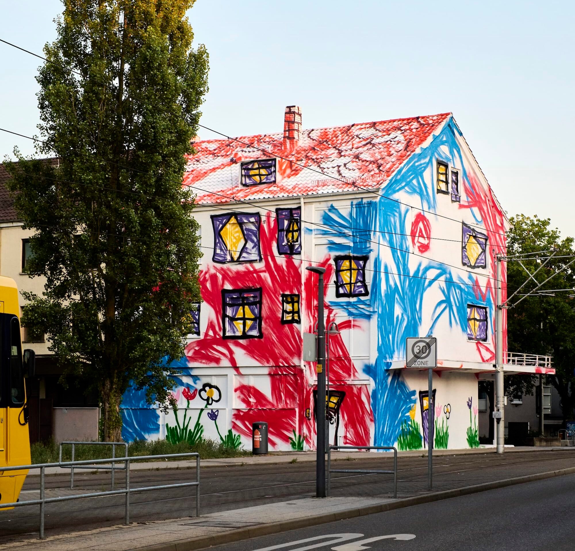 A mural by The Wa transforming a building facade with childlike, colorful drawings for the A Kid Could Do It series.