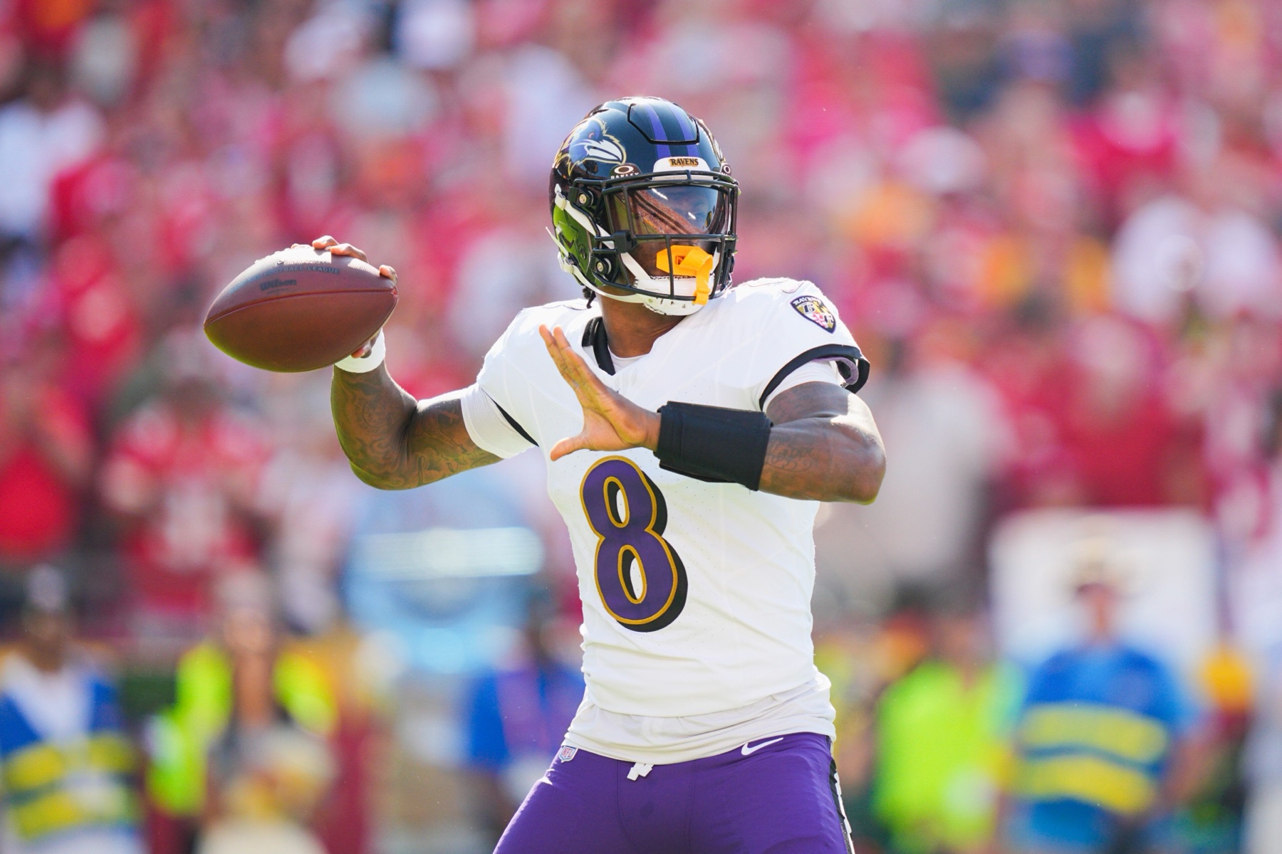 Ravens quarterback Lamar Jackson in a white number 8 jersey throwing a pass