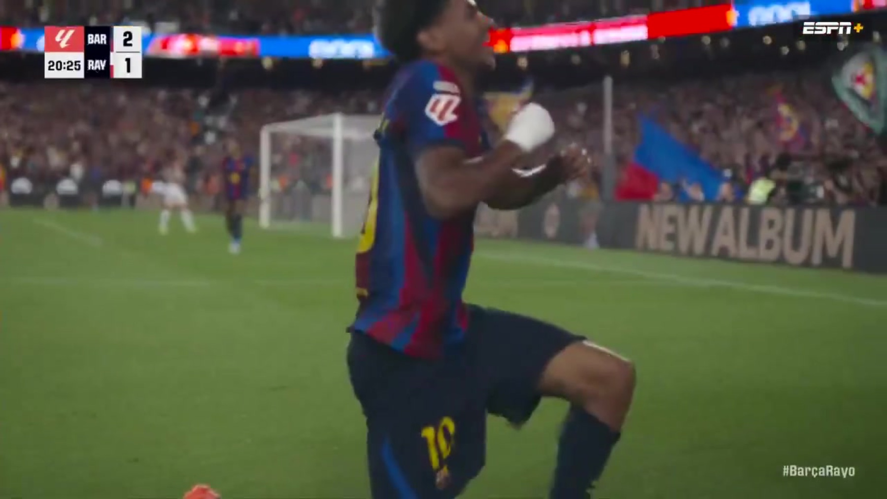 Lamine Yamal celebrating on his knees in the Barcelona number 10 shirt at Camp Nou with the scoreboard showing Barcelona 2 Rayo Vallecano 1